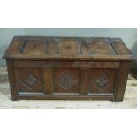 A 17th century oak kist the triple panelled top above a front with carved frieze and lozenge
