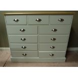 A modern chest of drawers the stripped oak top above three short drawers with eight long drawers