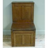 British Sanitary Company, Glasgow - an oak commode the hinged seat revealing enamelled liner above