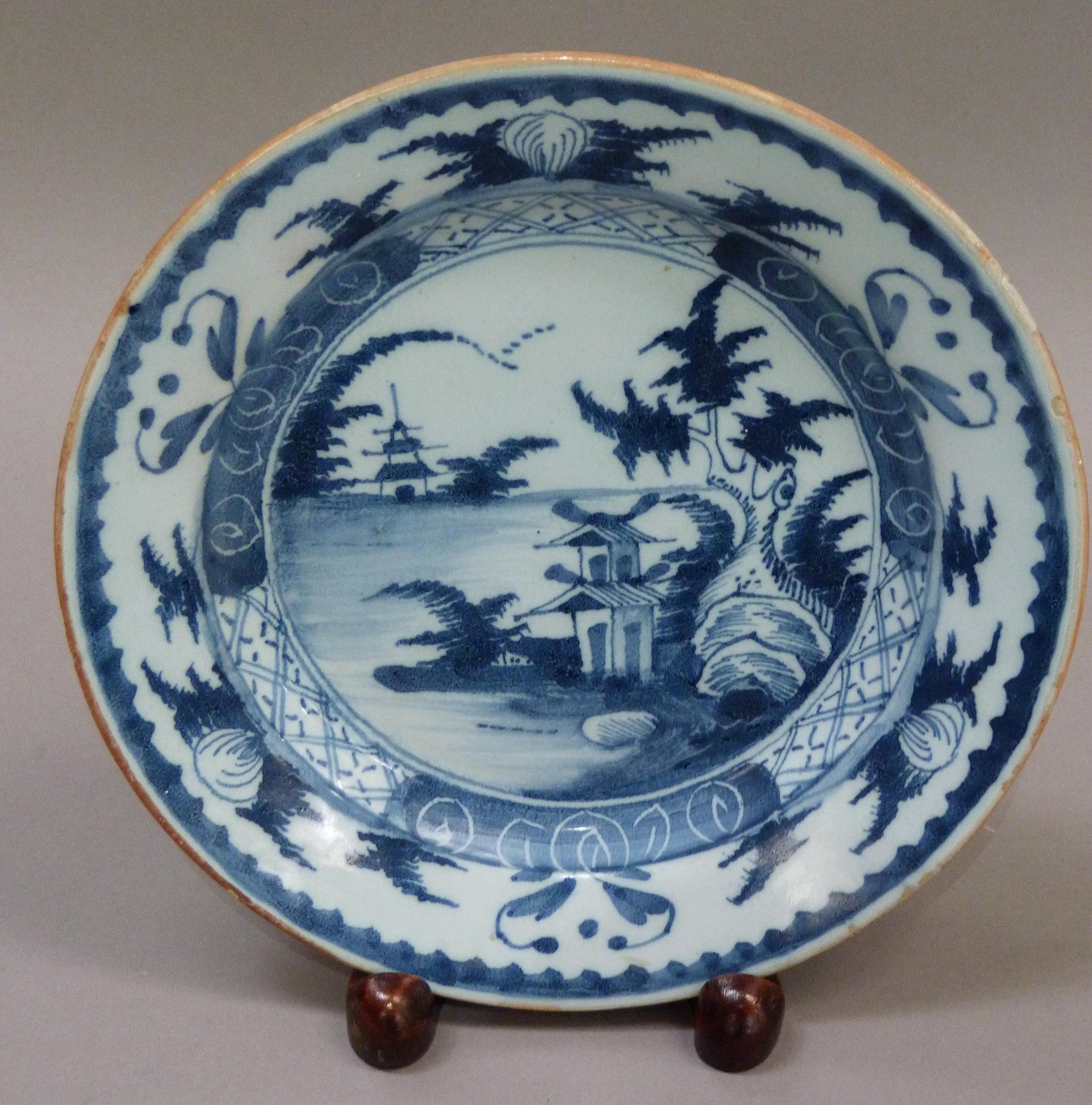 An 18th century delft plate painted in blue and white with a pagoda island river landscape, 23cm