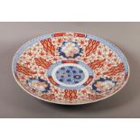 A JAPANESE IMARI CHARGER, Meiji period, painted in underglaze blue and iron red with scrolling