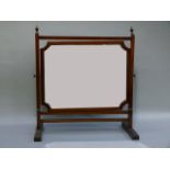 A mahogany toilet mirror having a rectangular plate with cut away corners and on square tapered