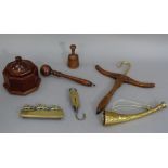 A brass and elm boot jack, a brass hunting horn, pocket balance scale, triple horse hearth ornament,