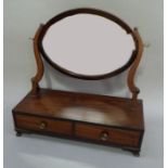 A mahogany dressing table mirror in George III style, the oval plate on a pair of s-shaped supports,