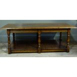 A reproduction oak coffee table, the rectangular plank top above turned legs with pot board under