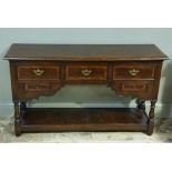 A reproduction oak dresser base in early 18th century style the rectangular top above three short
