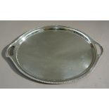 An oval two handled silver tray by Walker and Hall with gadroon rim engraved with the initial S to