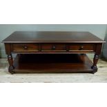 A reproduction coffee table, the rectangular top fitted three panelled short drawers on turned