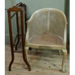 A bleached mahogany bergere tub chair of swept form applied rosettes to the arm terminals and