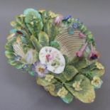 A 19th century porcelain basket of lattice work, applied with primroses and leaves on a pedestal