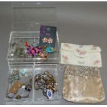 A quantity of costume jewellery in a perspex box including enamelled necklace, rings, pendants,