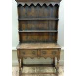 A reproduction oak dresser the flared cornice above shaped frieze twin shelved back projecting
