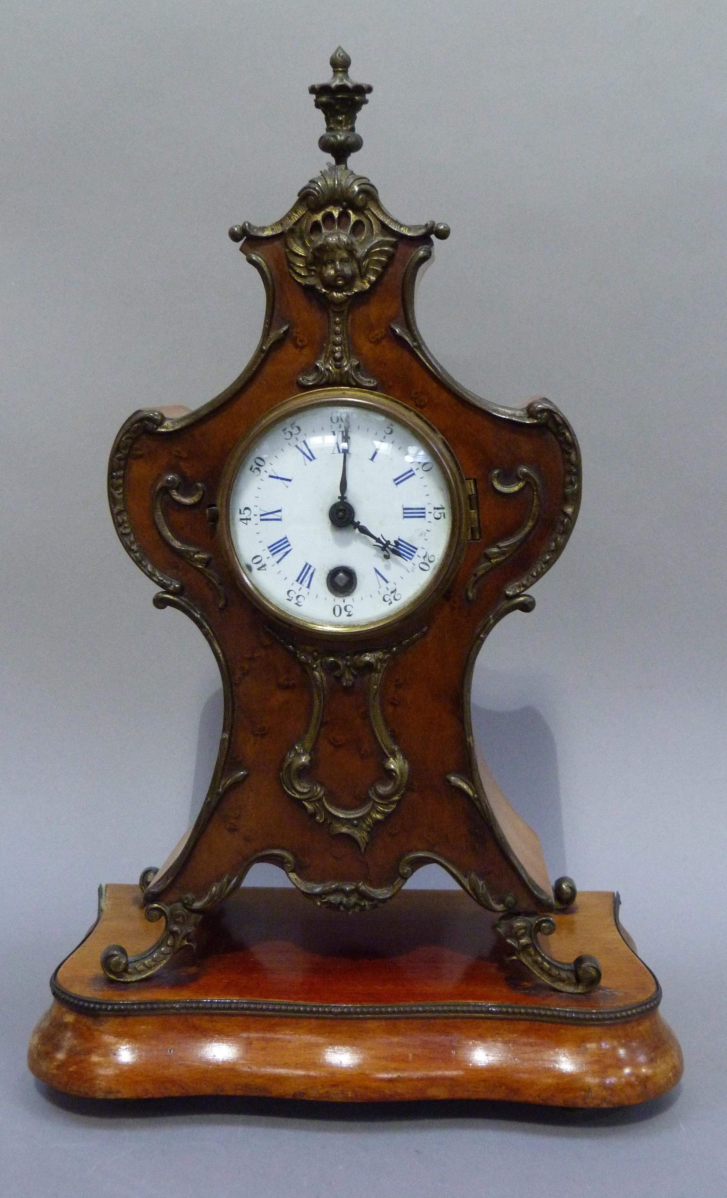 A Rococo style mantel clock in polished beech the front panel veneered with birds eye maple