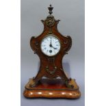 A Rococo style mantel clock in polished beech the front panel veneered with birds eye maple