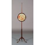 A 19th century mahogany pole screen having a circular banner inset with floral gros point, on a