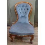 A Victorian walnut framed button back nursing chair upholstered in pale blue Draylon on scrolling