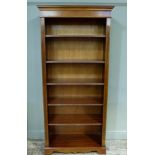 A reproduction mahogany bookcase with adjustable shelves the flared cornice above fluted pillars,