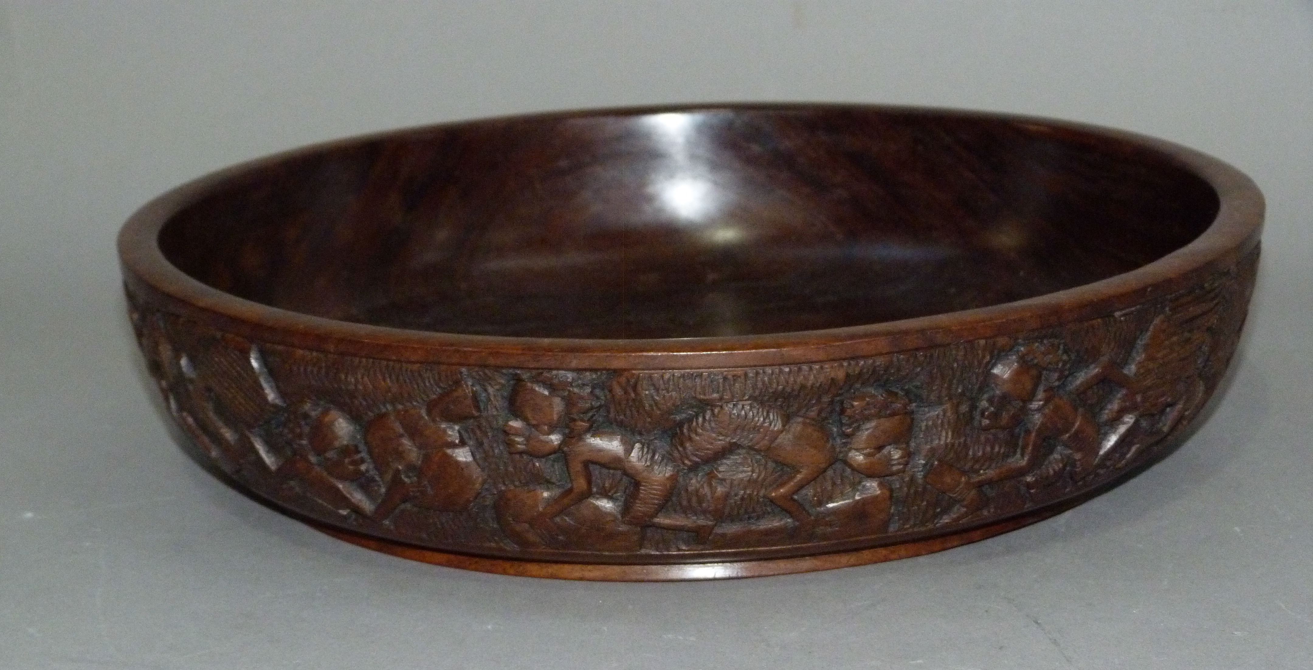 An African hardwood bowl the exterior carved with a continuous scene of figures, 34.5cm - Image 2 of 2