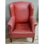 An Edwardian mahogany framed wing back arm chair upholstered in red rexine
