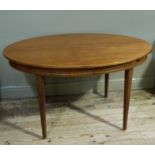 A mahogany extending dining table, figured oval top above a brass inlaid frieze on turned tapered
