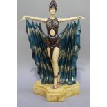 A reproduction resin Art Deco figure of a female with arms outstretched and hung with a cape on
