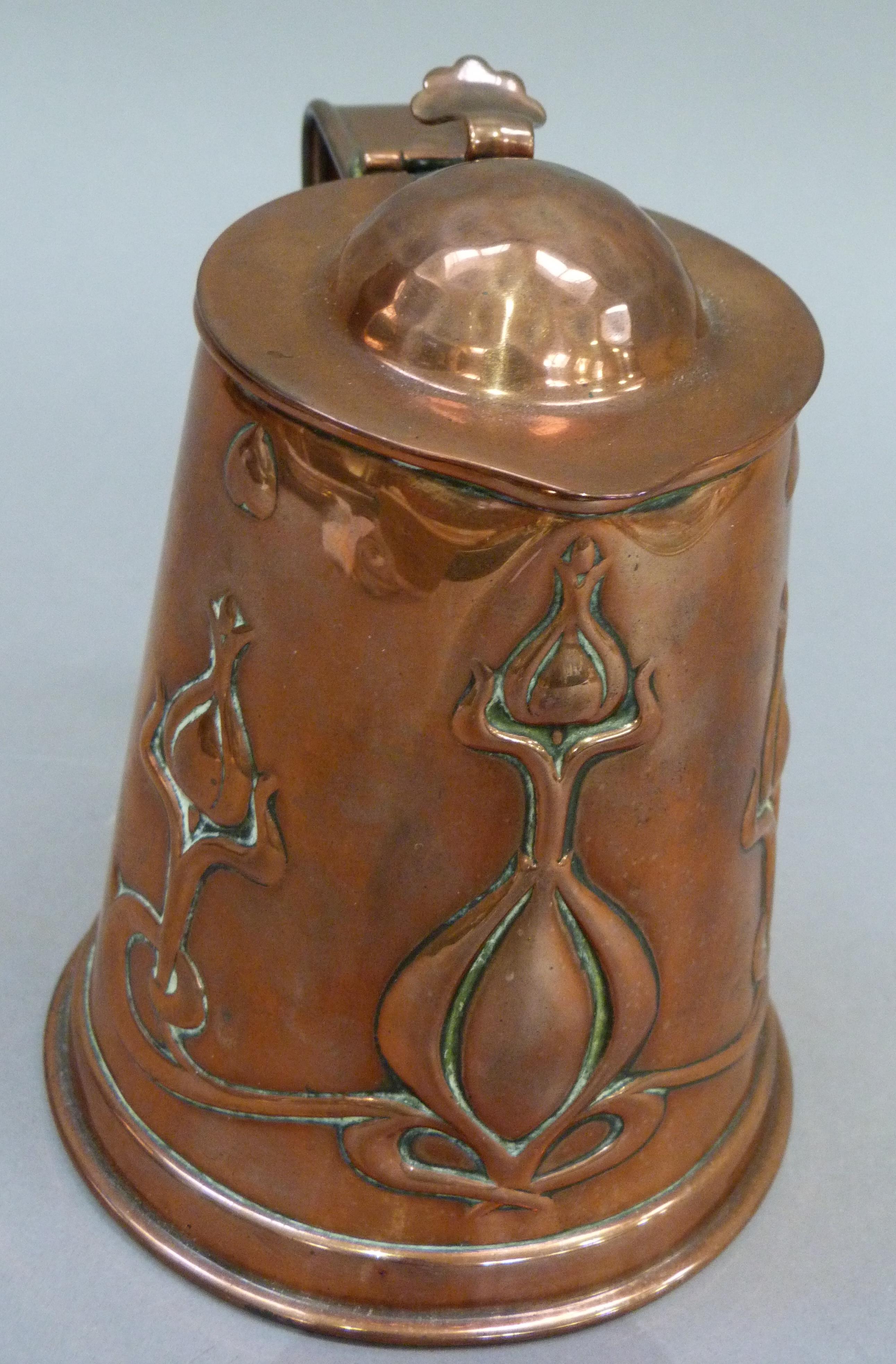 An Art Nouveau copper jug having a domed cover with thumb piece the tapered body embossed with - Image 2 of 3