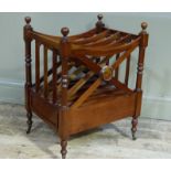 A reproduction mahogany four compartment Canterbury of conventional form on turned supports with