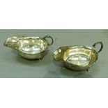 A pair of silver sauce boats with flying scroll handles on two hoof feet, Birmingham 1935,