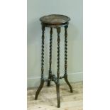 A 1920s oak plant stand on four barley twist legs joined by cross stretcher