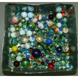 A quantity of vintage marbles contained in a tin box