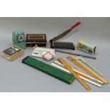 Vintage office equipment including guillotine, pencil sharpener, clock face, rubber stamp, rules,