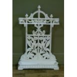 A Victorian style cast iron umbrella stand of arched outline the frame pierced with inner design