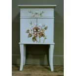 An off white painted bedside cabinet with drawer and two door cupboard painted with flowers
