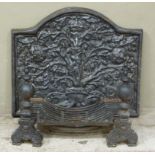A pair of cast iron firedogs of baluster outline together with an arched fireback and grate