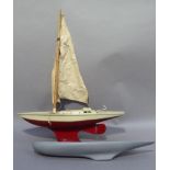 A Tri-ang C20 tin plate sailing boat with red painted hull, cream deck and cabin, cotton sail