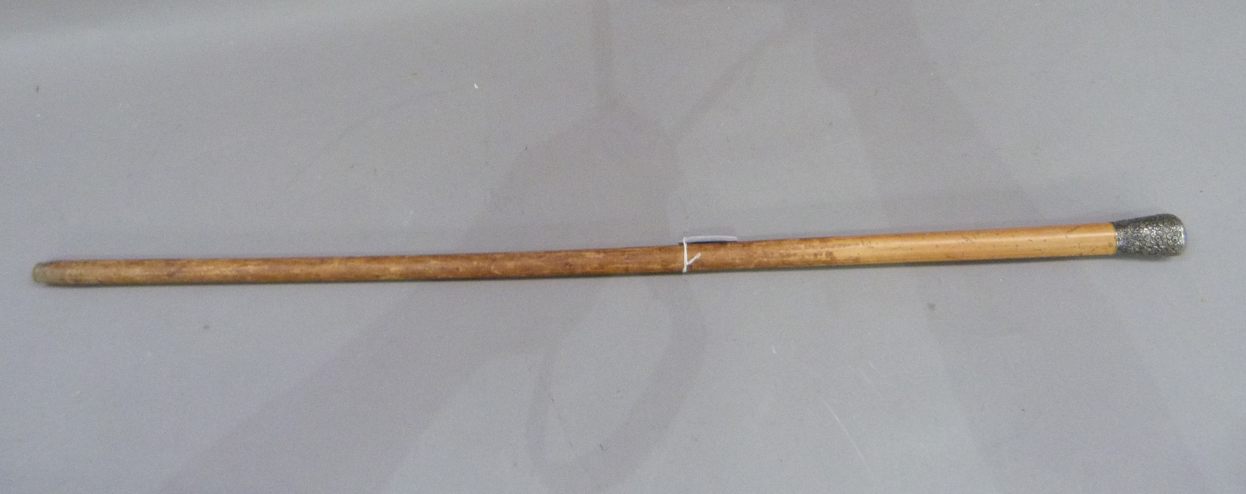 A gentleman's walking cane, the silver foliate embossed pommel above a tapered stick