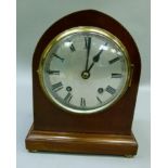An Edwardian mantel clock of arched outline having ebony and boxwood chequered stringing, the