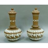 A pair of Doulton silicon vases and covers, the rounded body sprigged in white with a band of