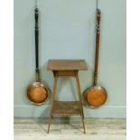 Two copper warming pans on fruitwood and ebonised turned handles, together with a two tier