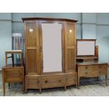 A good walnut four piece bedroom suite in the manner of Libertys the wardrobe with flared cavetto