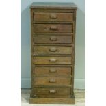 A narrow chest of eight graduated drawers with bar handle and on plinth base, 56cm wide x 45cm deep