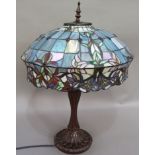 A large Tiffany style glass table lamp with shaped shade in blue, pink, pale green, brown and white,