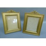 A pair of gilt metal photograph frames, rectangular with ribboned floral cresting and with back