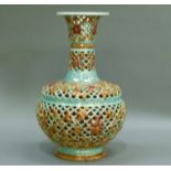 A continental reticulated ceramic vase in the style of Zsolnay, enamelled in pale turquoise green