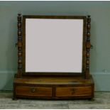 An early 19th century mahogany toilet mirror with rectangular plate turned uprights, the two