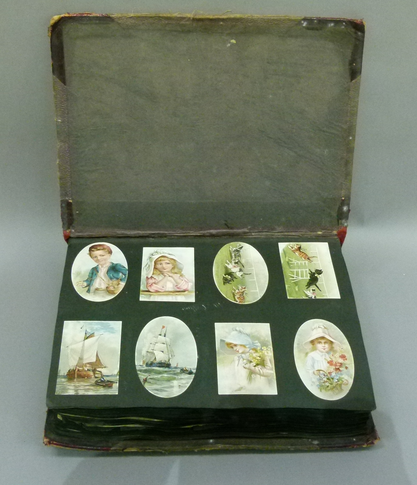 A Victorian scrap album oval and rectangular cards, various subject matters including cats,