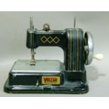 A childs Vulcan sewing machine, black enamelled with gilt detailing, 23cm wide over handle