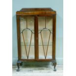 A 1930s/40s mahogany display cabinet having a raised back over two tracery glazed doors with glass