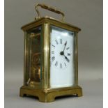 A brass carriage clock with key, white enamelled dial with black Roman numerals, 15cm overhandles