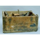 Wooden Gordon's crate containing a selection of vintage tools - hand saws, drill, hammer, chisels,